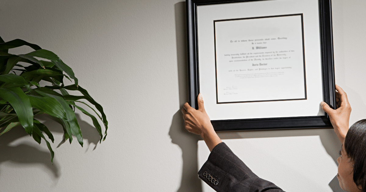 picture-of-woman-hanging-hr-certificate-in-office-iq-academy-hr-career